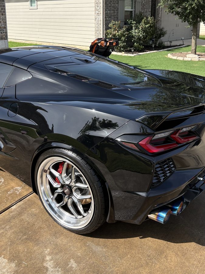 Black Chevrolet Corvette C8 Stingray rear three quarter with a mirror gloss finish after an exterior detail