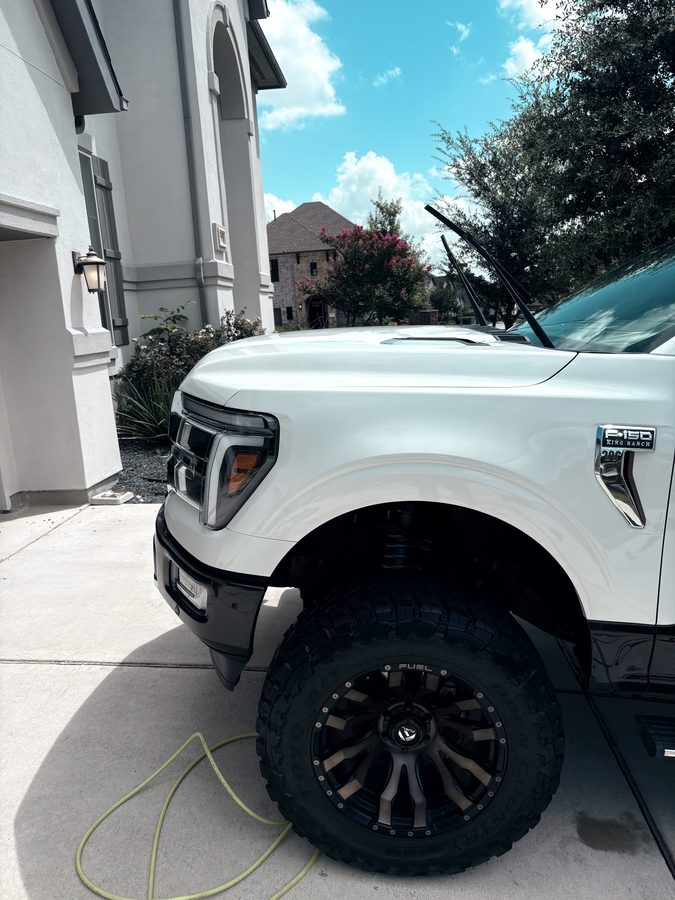 Lifted white Ford F-150 King Ranch with a glossy front end after an exterior detail
