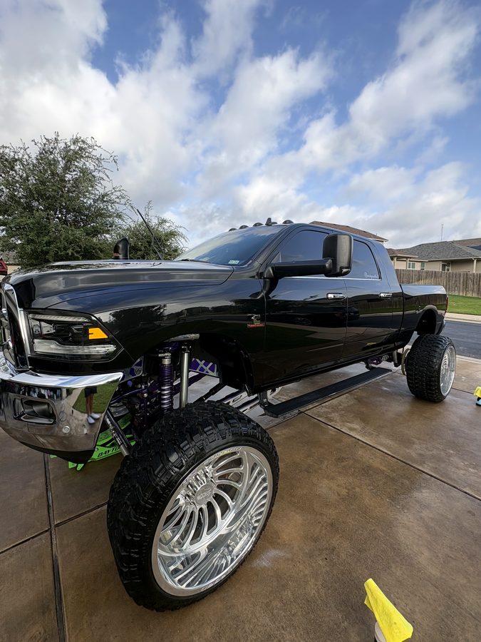 Lifted black Ram mega cab on polished forged wheels with a deep gloss finish after an exterior detail