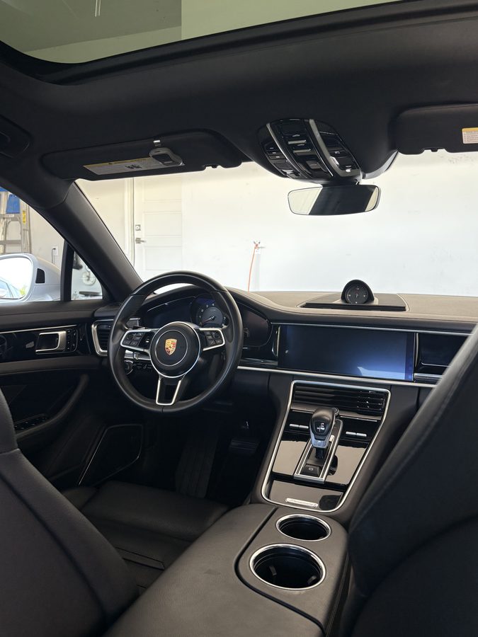 Porsche Panamera cabin with crest steering wheel and detailed black leather interior